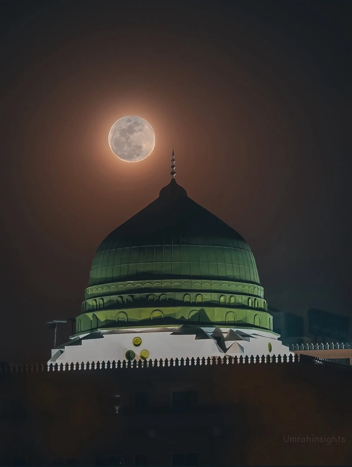 The green dome of the Prophet's Mosque under a full moon